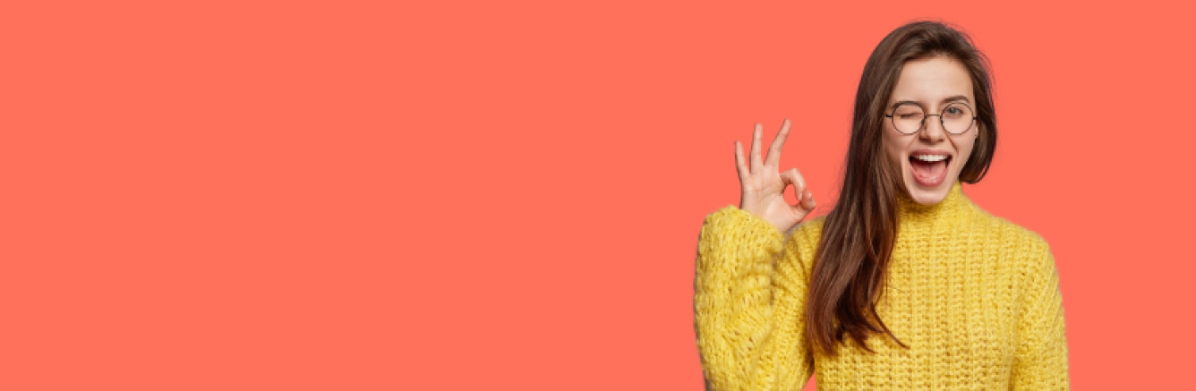 Mujer sonriente con jersey amarillo de punto sosteniendo las llaves de su nuevo piso